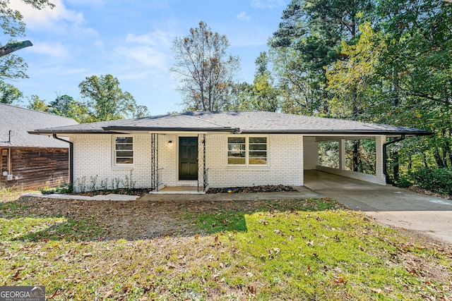 view of front of property with driveway, fence, an attached carport, and brick siding