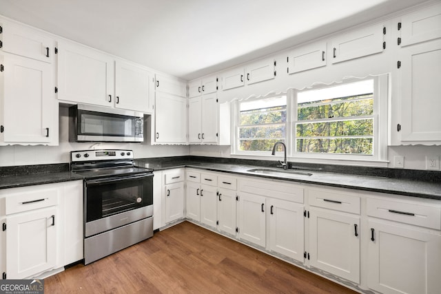 kitchen featuring stainless steel appliances, white cabinets, and a sink