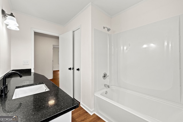 bathroom with ornamental molding, shower / bathing tub combination, vanity, and wood finished floors