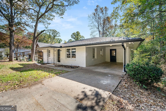 single story home with an attached carport, brick siding, and driveway