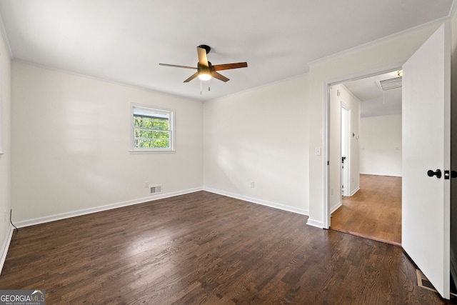 empty room featuring dark wood-style floors, ornamental molding, visible vents, and attic access