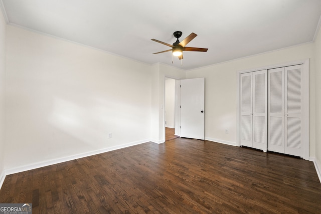 unfurnished bedroom with dark wood finished floors, a closet, ornamental molding, a ceiling fan, and baseboards