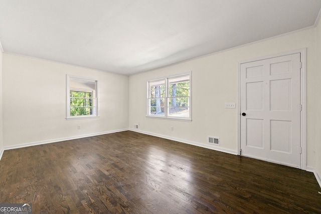 unfurnished room with dark wood-style floors, visible vents, and baseboards