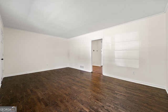 empty room featuring baseboards, visible vents, and dark wood finished floors