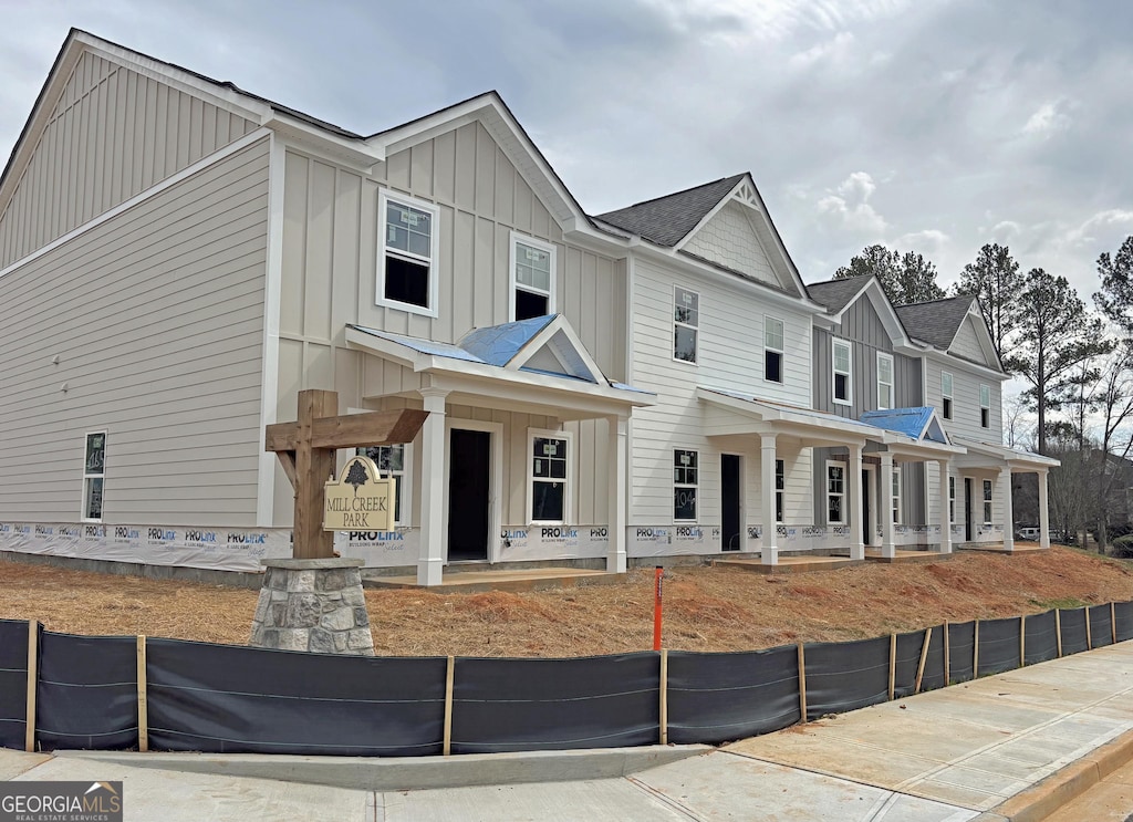 townhome / multi-family property featuring covered porch and board and batten siding