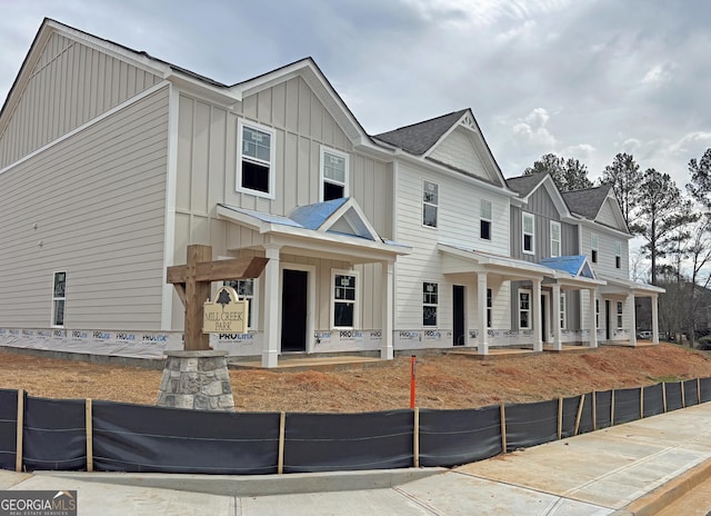 townhome / multi-family property featuring covered porch and board and batten siding