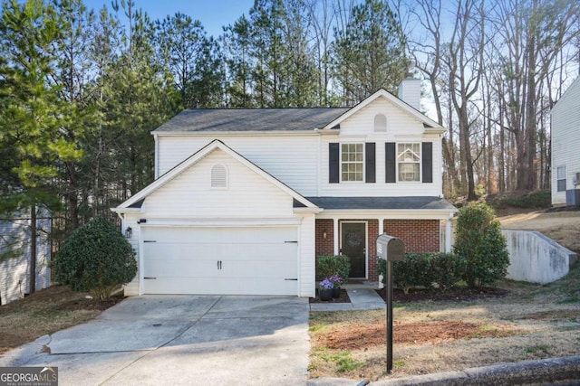 traditional-style house featuring driveway, brick siding, a chimney, and an attached garage