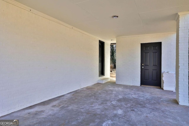 empty room with brick wall and unfinished concrete floors