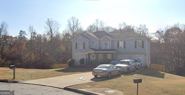 traditional-style home featuring a front yard, driveway, and an attached garage