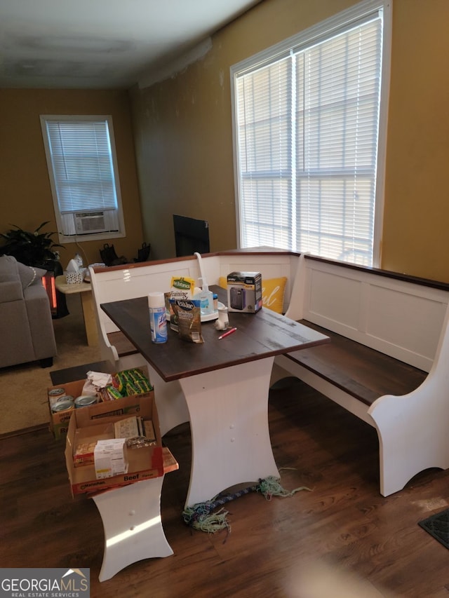 dining space featuring a wainscoted wall, cooling unit, and wood finished floors