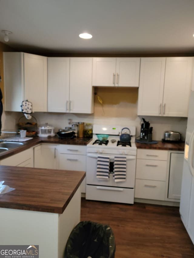 kitchen with white appliances, dark wood-style flooring, wood counters, and white cabinetry