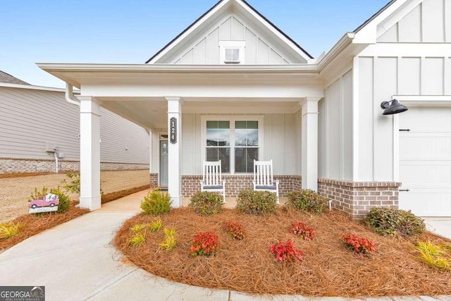 property entrance with an attached garage, brick siding, board and batten siding, and a porch