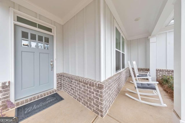 entrance to property featuring board and batten siding and brick siding