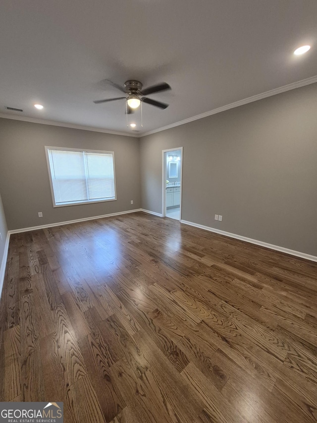 unfurnished room with dark wood-style flooring, visible vents, baseboards, a ceiling fan, and ornamental molding