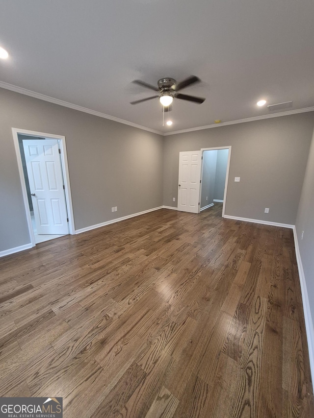 spare room featuring ceiling fan, baseboards, wood finished floors, and crown molding