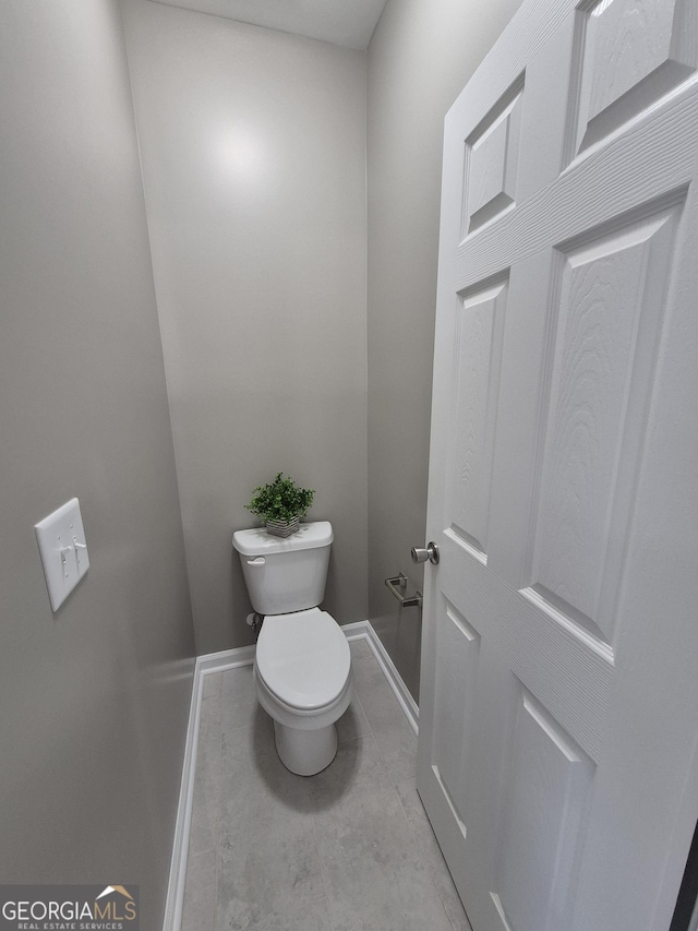 bathroom with toilet and baseboards