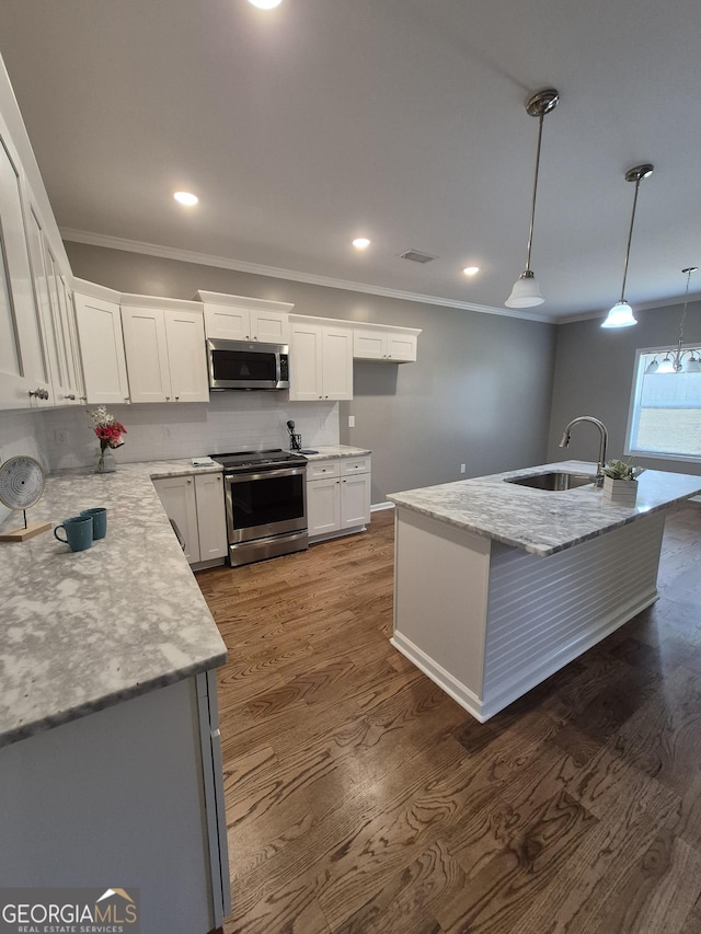 kitchen featuring dark wood-style flooring, stainless steel appliances, visible vents, ornamental molding, and a sink