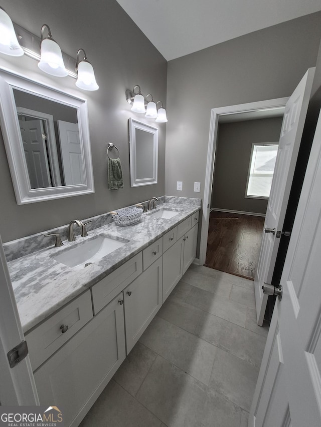 full bathroom with double vanity, a sink, and tile patterned floors