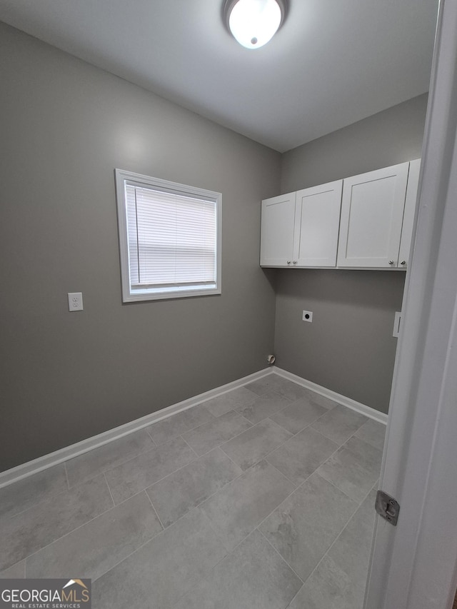 washroom featuring cabinet space, baseboards, and hookup for an electric dryer