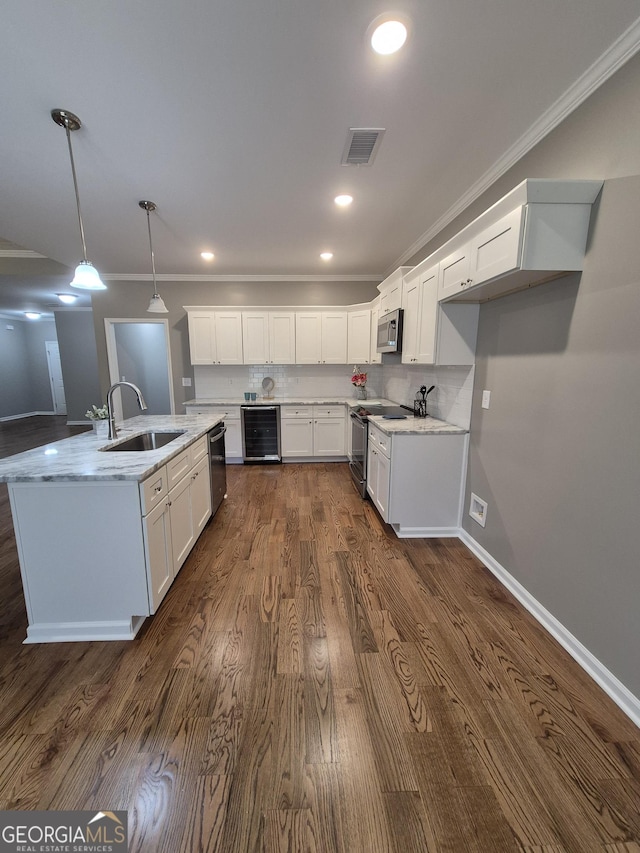 kitchen featuring wine cooler, stainless steel appliances, a sink, visible vents, and ornamental molding