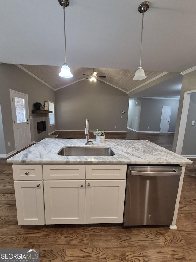 kitchen with open floor plan, stainless steel dishwasher, a sink, and light stone countertops