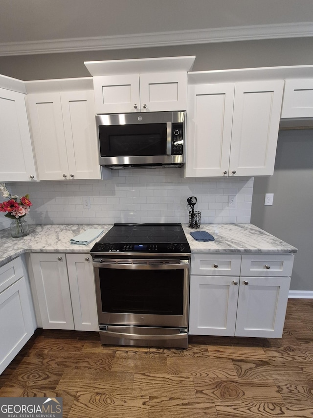 kitchen with stainless steel appliances, white cabinetry, ornamental molding, and backsplash