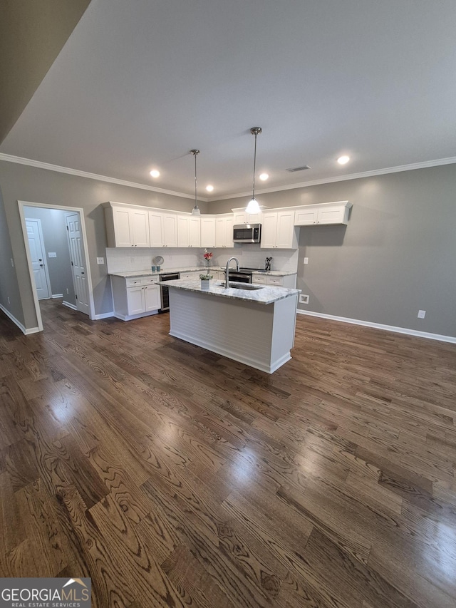 kitchen featuring stainless steel microwave, dark wood-type flooring, white cabinets, a sink, and light stone countertops