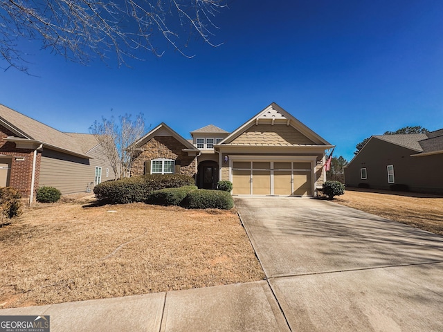 view of front of home with a garage, stone siding, and concrete driveway
