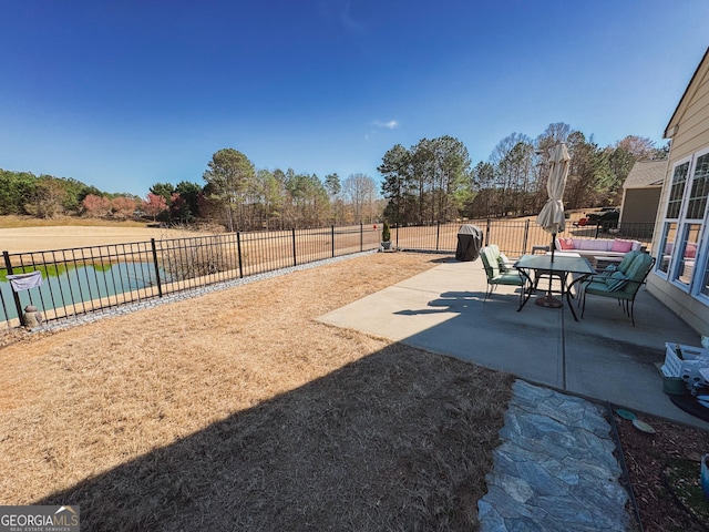 view of patio / terrace featuring a water view and fence
