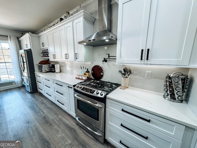 kitchen featuring stainless steel appliances, dark wood-type flooring, white cabinets, backsplash, and wall chimney exhaust hood