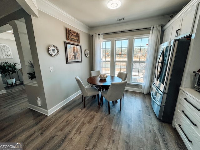 dining space featuring baseboards, dark wood-type flooring, visible vents, and crown molding