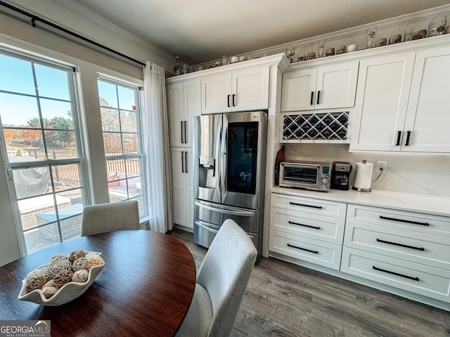 kitchen with a toaster, stainless steel fridge, dark wood-style flooring, and white cabinets