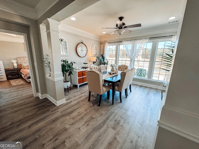dining room featuring crown molding, ornate columns, a ceiling fan, wood finished floors, and baseboards