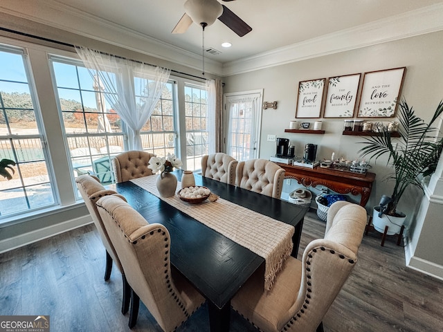 dining area featuring a healthy amount of sunlight, crown molding, baseboards, and wood finished floors