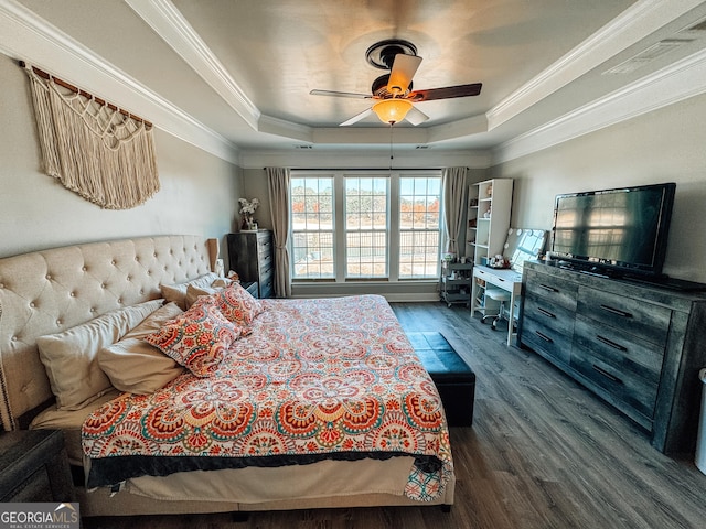 bedroom with wood finished floors, a raised ceiling, a ceiling fan, and crown molding