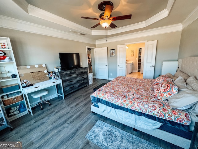 bedroom featuring ornamental molding, a raised ceiling, visible vents, and wood finished floors