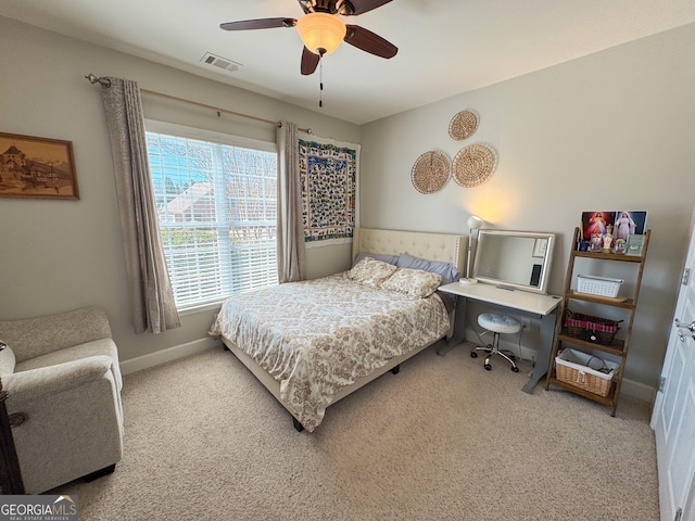 bedroom with wainscoting, visible vents, ceiling fan, and carpet flooring