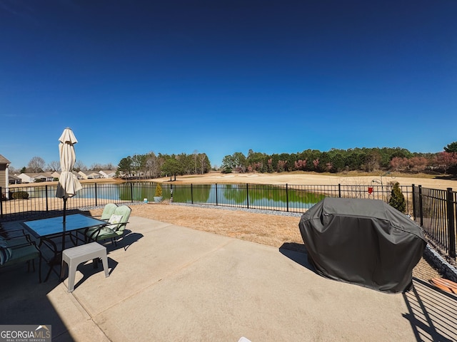 view of patio / terrace featuring area for grilling, outdoor dining area, a water view, and fence