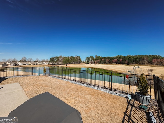 view of patio / terrace featuring a water view and fence