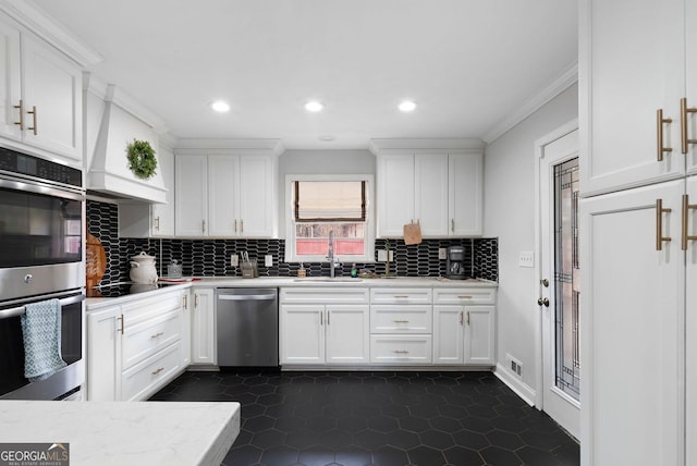 kitchen featuring a sink, stainless steel appliances, light countertops, and white cabinets