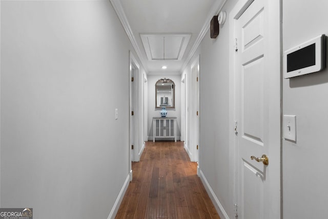 hallway featuring dark wood finished floors, attic access, and baseboards