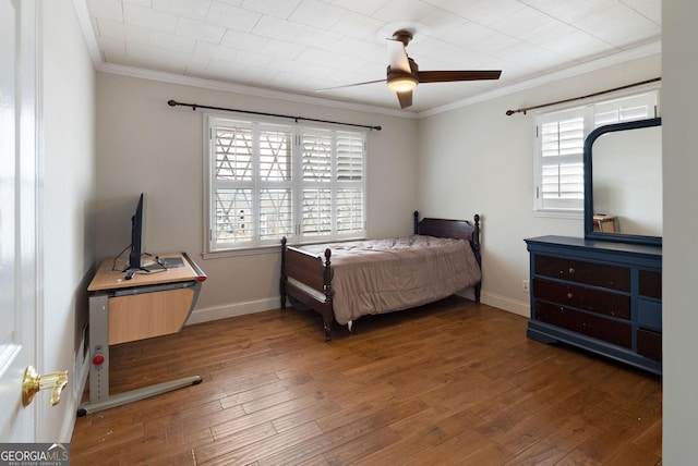 bedroom with baseboards, ceiling fan, wood finished floors, and crown molding