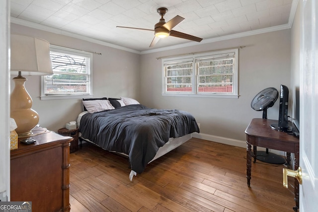 bedroom with crown molding, baseboards, ceiling fan, and wood finished floors