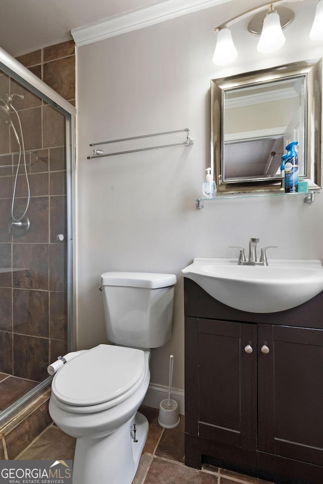 bathroom featuring tile patterned flooring, toilet, vanity, a shower stall, and crown molding