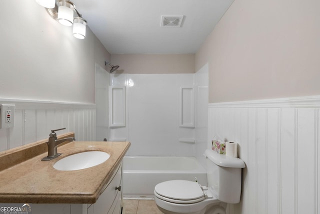 bathroom featuring tile patterned flooring, vanity, visible vents, shower / bathing tub combination, and wainscoting