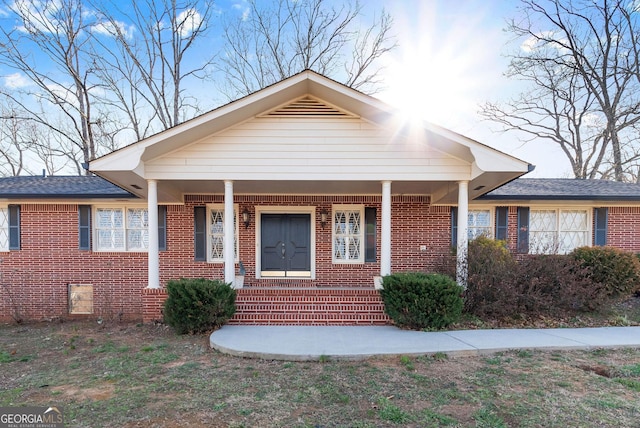 bungalow featuring brick siding