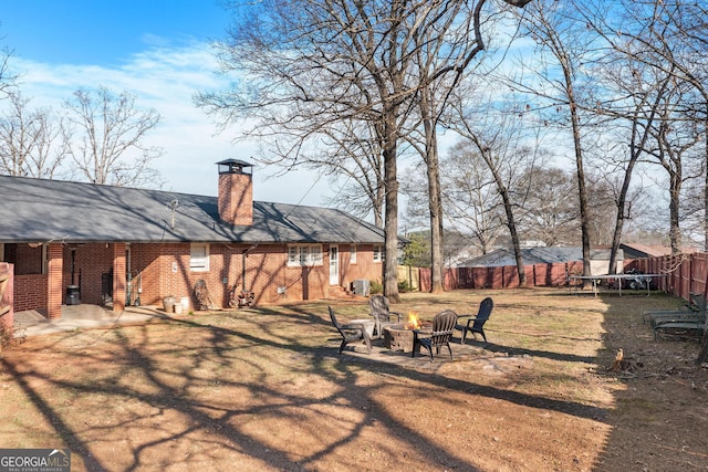 view of yard with an outdoor fire pit, a trampoline, a fenced backyard, and a patio