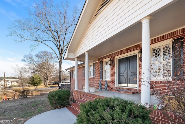 property entrance with covered porch and brick siding