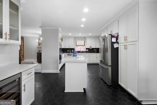 kitchen featuring beverage cooler, stainless steel appliances, light countertops, and white cabinetry