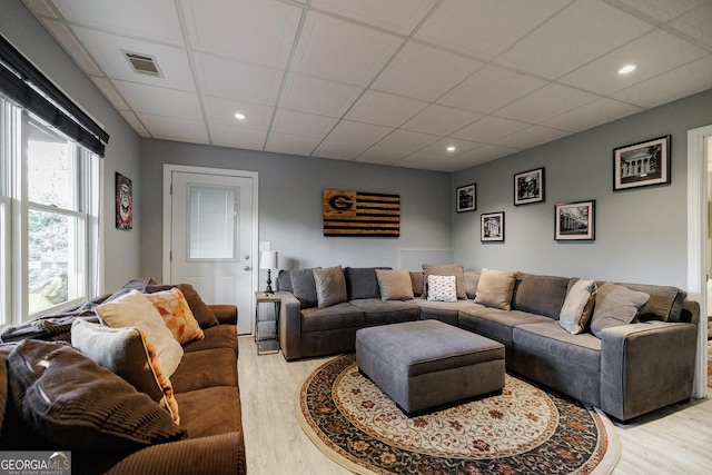 living area featuring light wood-style floors, a paneled ceiling, visible vents, and recessed lighting